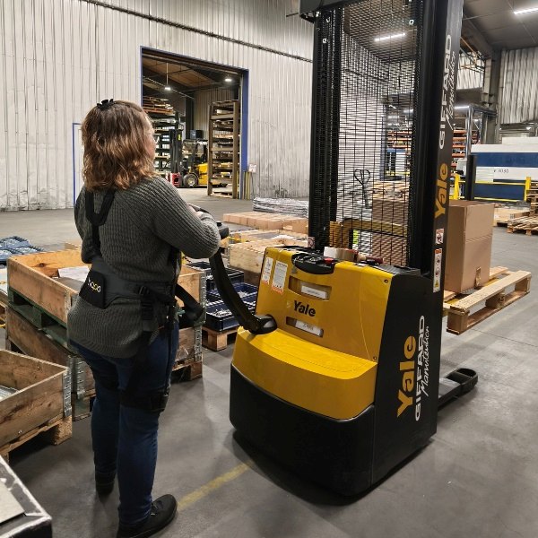 employée logistique de la tôlerie Teoplus avec son trangerbeur et son exosquelette