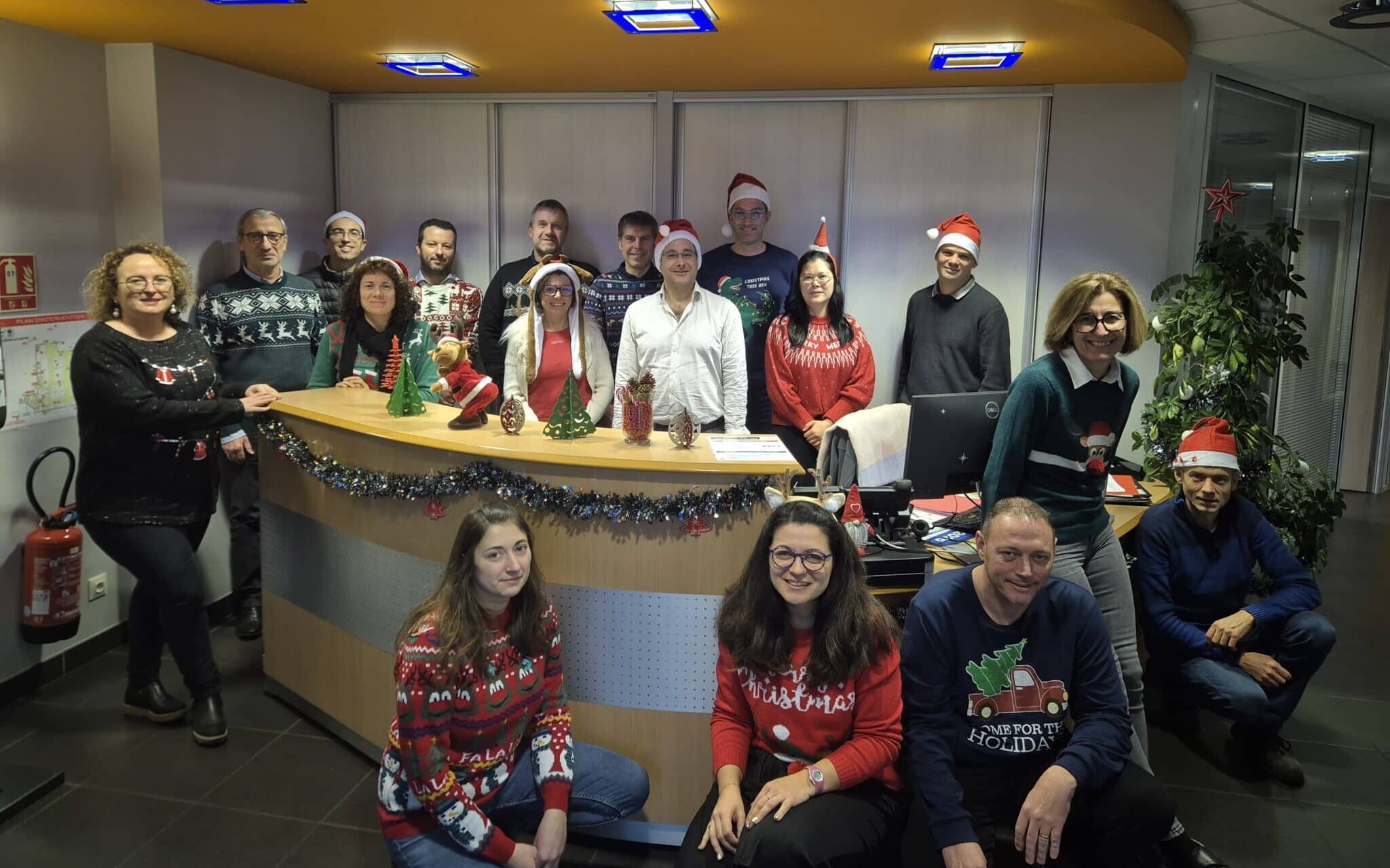 une quinzaine de techniciens et employés de bureaux de la tôlerie Teoplus avec des pulls de Noel