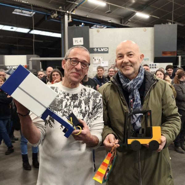 2 hommes en âge de partir à la retraite, tiennent chacun une miniature, d'une machine laser Trumpf et d'un engin de cariste