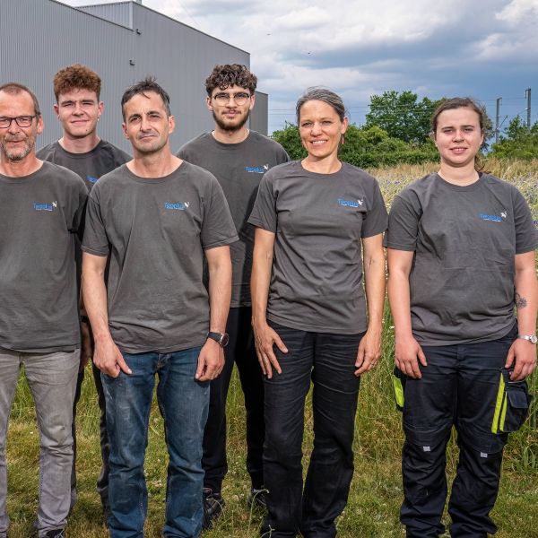 2 femmes et 4 hommes avec le t-shirt de Teoplus devant le site de thermolaquage