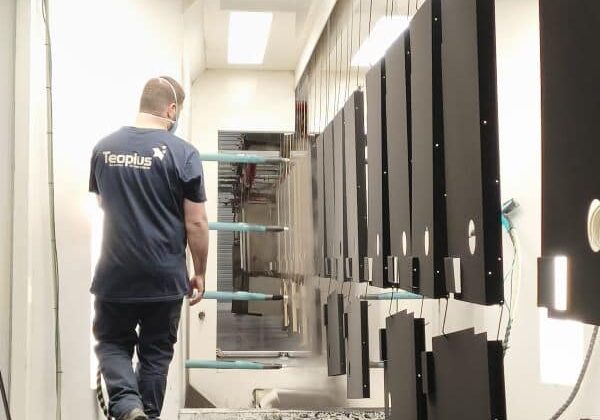 peintre-poudreu avec un t-shirt Teoplus dans la cabine de poudrage automatique